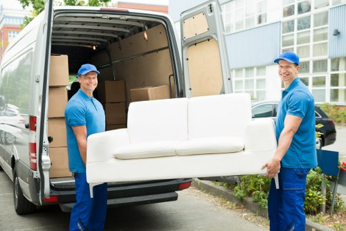 Moving team handling boxes and furniture in a Marylebone street setting